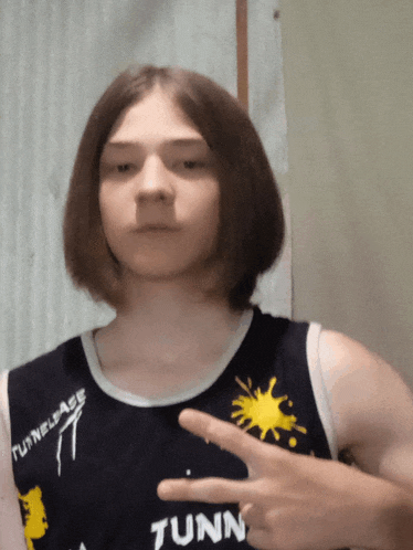 a young man wearing a tank top that says tunnelage
