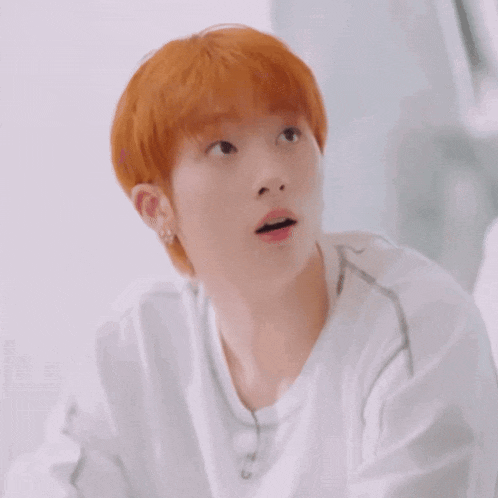 a young man with red hair is wearing a white shirt