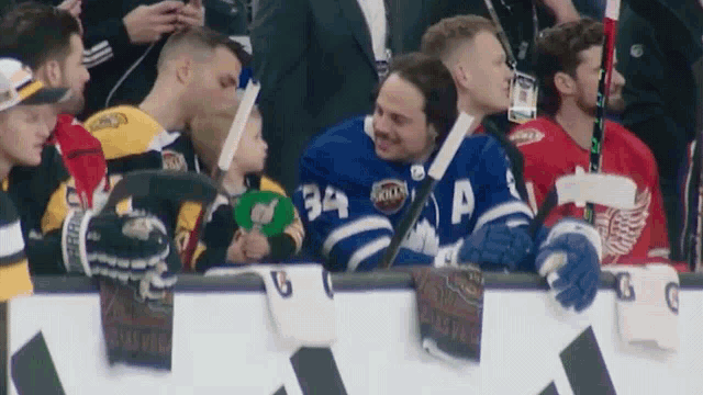 a hockey player wearing number 34 talks to a little girl
