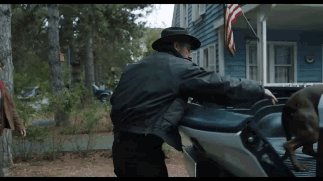 a man in a hat is loading a motorcycle into a truck