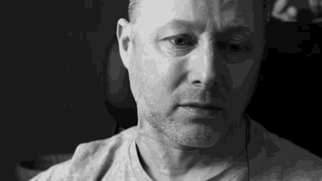 a black and white photo of a man wearing headphones .
