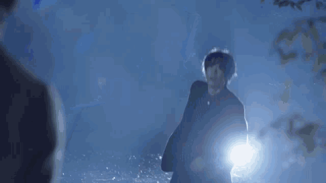 a person standing in the dark with a light shining on them .