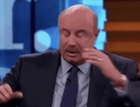 a man in a suit and tie is making a funny face while talking on a television show .