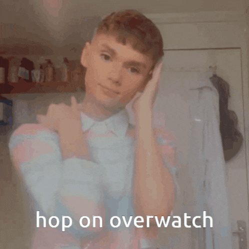 a young man is standing in front of a door with the caption hop on overwatch