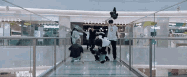 a group of people are doing a trick on a glass walkway