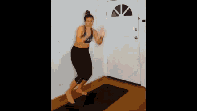 a woman wearing a tank top that says fox stands on a yoga mat