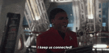 a woman in a red jacket is holding a laptop and saying `` i keep us connected ! ''