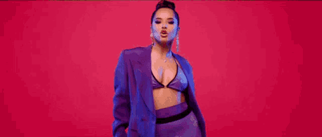 a woman is wearing a purple suit and a purple bra .