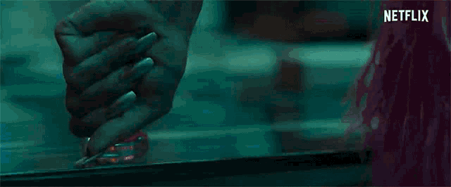 a close up of a woman 's hand holding a bottle of nail polish