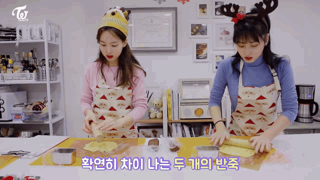 two girls are preparing food in a kitchen and one has a twice logo on her head