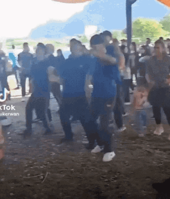 a group of people are dancing under a tent with tik tok written on the bottom