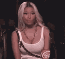 a woman in a white tank top is sitting in a chair holding a coca cola can .