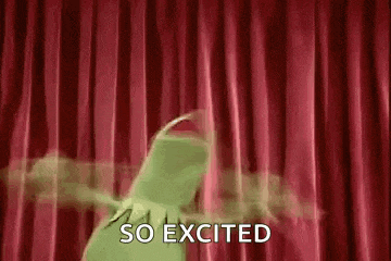 kermit the frog is dancing on a stage with a red curtain behind him .