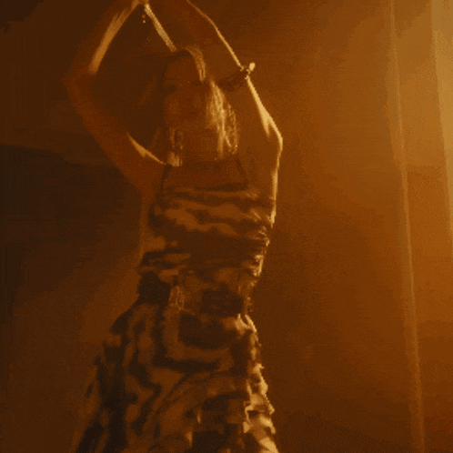 a woman playing a violin in a dark room with a yellow background