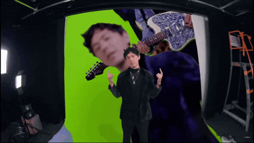 a man holding a guitar giving the middle finger