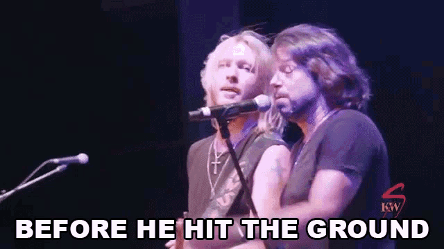 two men are singing into microphones on a stage with the words `` before he hit the ground '' written on the bottom .