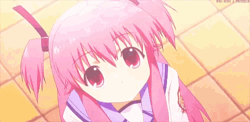 a girl with pink hair is giving a peace sign with her hands .