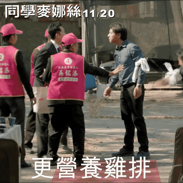 a man wearing a pink vest with the number 4 on it talks to another man