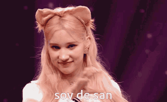 a woman wearing a headband with ears and the words soy de san