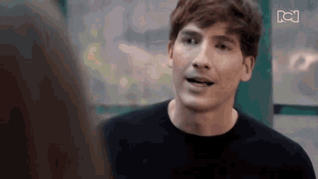 a man in a black shirt is talking to a woman in a green room .