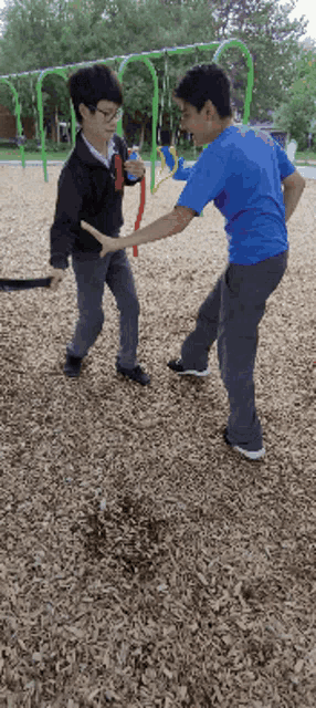 a boy in a blue shirt with the word eagles on the back is playing with another boy
