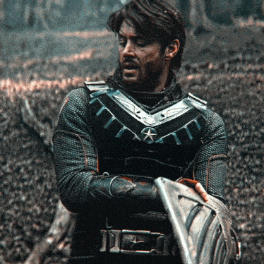a man in a knight 's costume holds a shield
