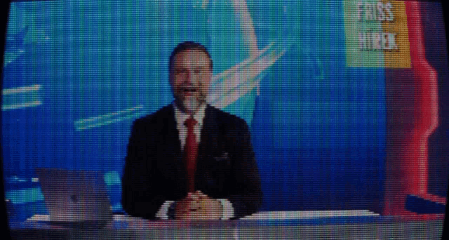 a man in a suit and tie stands in front of a screen that says fox news week