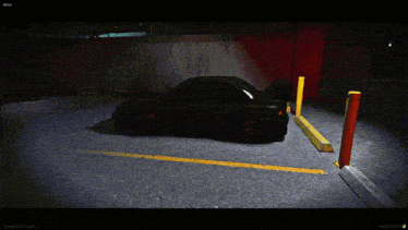 a black car is parked in a parking lot with a yellow curb