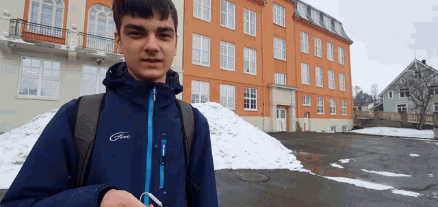 a young man wearing a blue jacket that says five