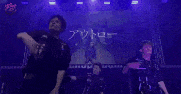 a group of young men are dancing on a stage in front of a screen that says we