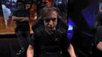 a man wearing headphones is sitting in a chair in front of a screen .