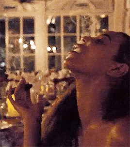 a woman is smoking a cigar in a room with smoke coming out of her mouth .