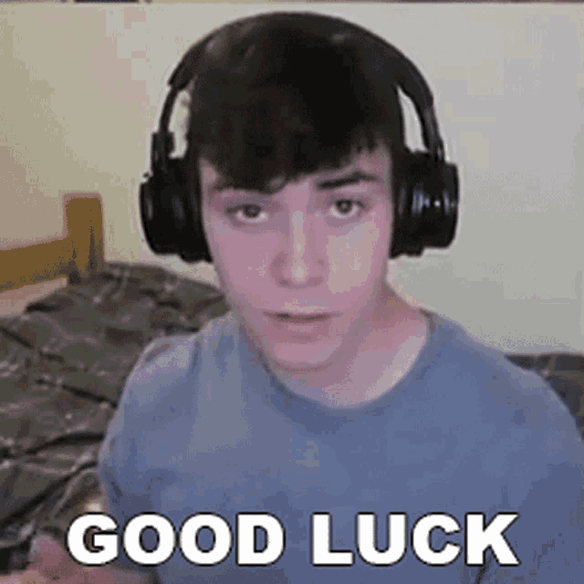 a young man wearing headphones is sitting in front of a bed .