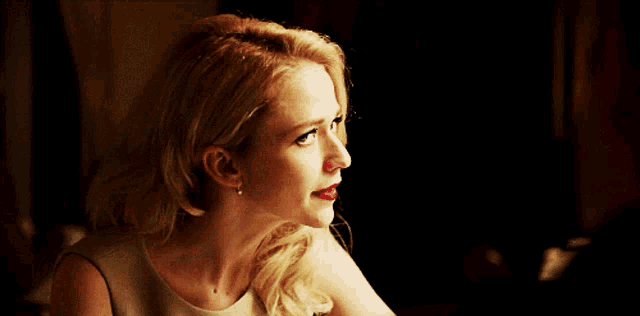 a woman with blonde hair and red lipstick is smiling