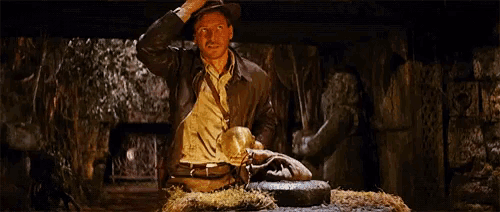 a man in a hat is sitting on a rock in a dark room .