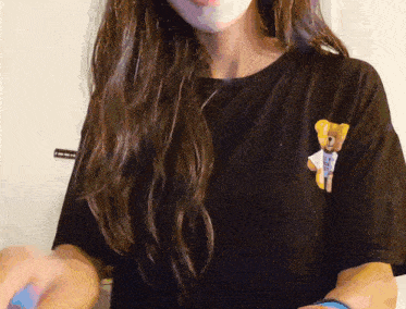 a woman wearing a black shirt with a teddy bear on the front