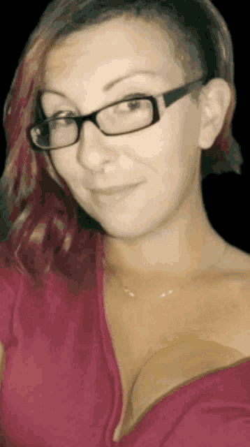 a woman wearing glasses and a red shirt smiles
