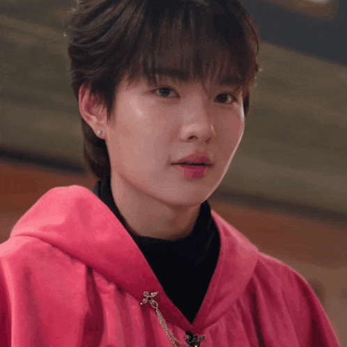 a close up of a person wearing a pink coat