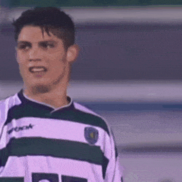 a soccer player wearing a white and green striped jersey with the number 10 on it
