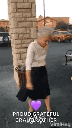 an elderly woman is dancing in a parking lot with a purple heart .