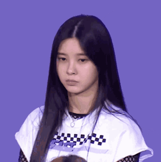 a woman wearing a white shirt with a checkered pattern on it