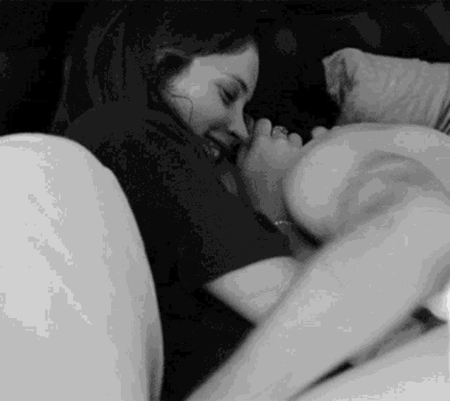 a black and white photo of a man and woman laying on a couch