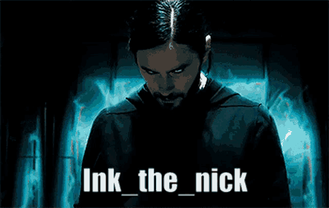 a man with a beard is standing in a dark room with the words ink the nick above him .