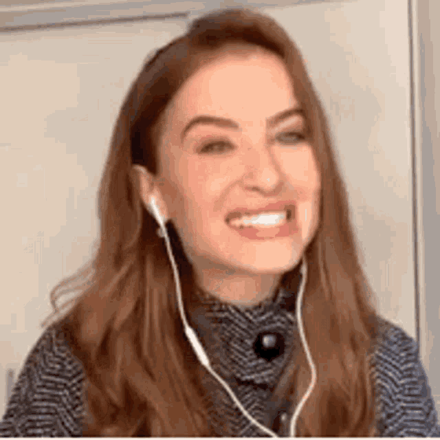 the woman is wearing headphones and smiling .