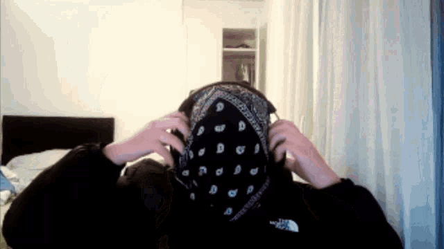a person wearing a bandana with the north face logo on the back