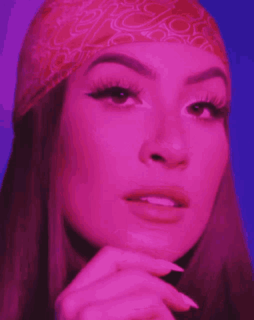 a close up of a woman 's face wearing a pink bandana