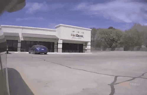 a car is parked in front of a building that says re door
