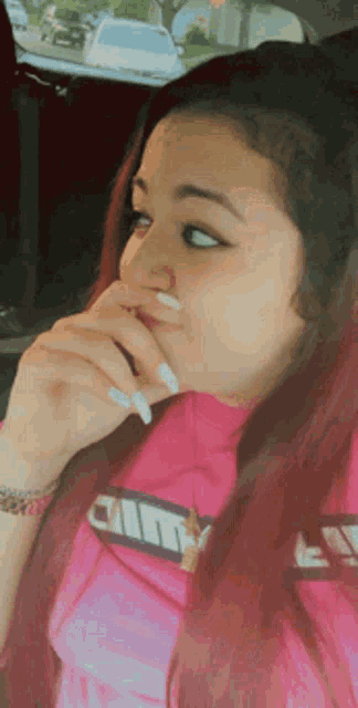 a woman with red hair wearing a pink shirt that says city