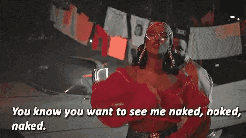 a woman in a red top is standing next to a man in a white car and talking to him while naked .