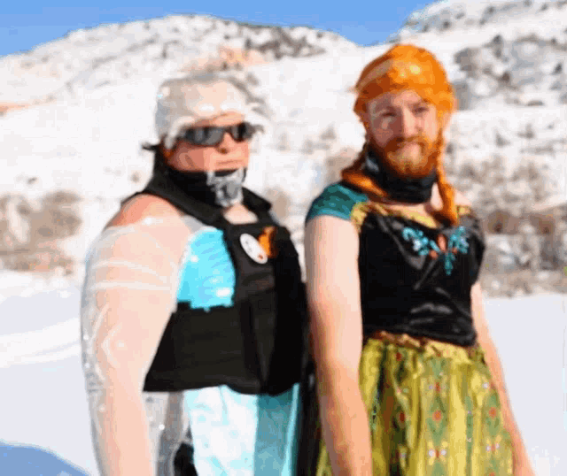 a man and a woman are standing next to each other in a snowy area